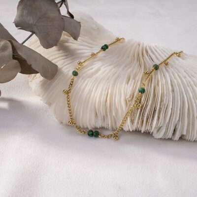 Goldene Halskette mit kleinen grünen Perlen