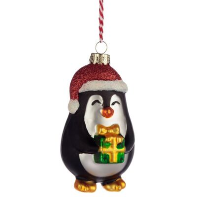 Pingüino con adorno navideño de cristal presente