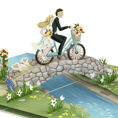 Tarjeta emergente de pareja de novios en bicicleta