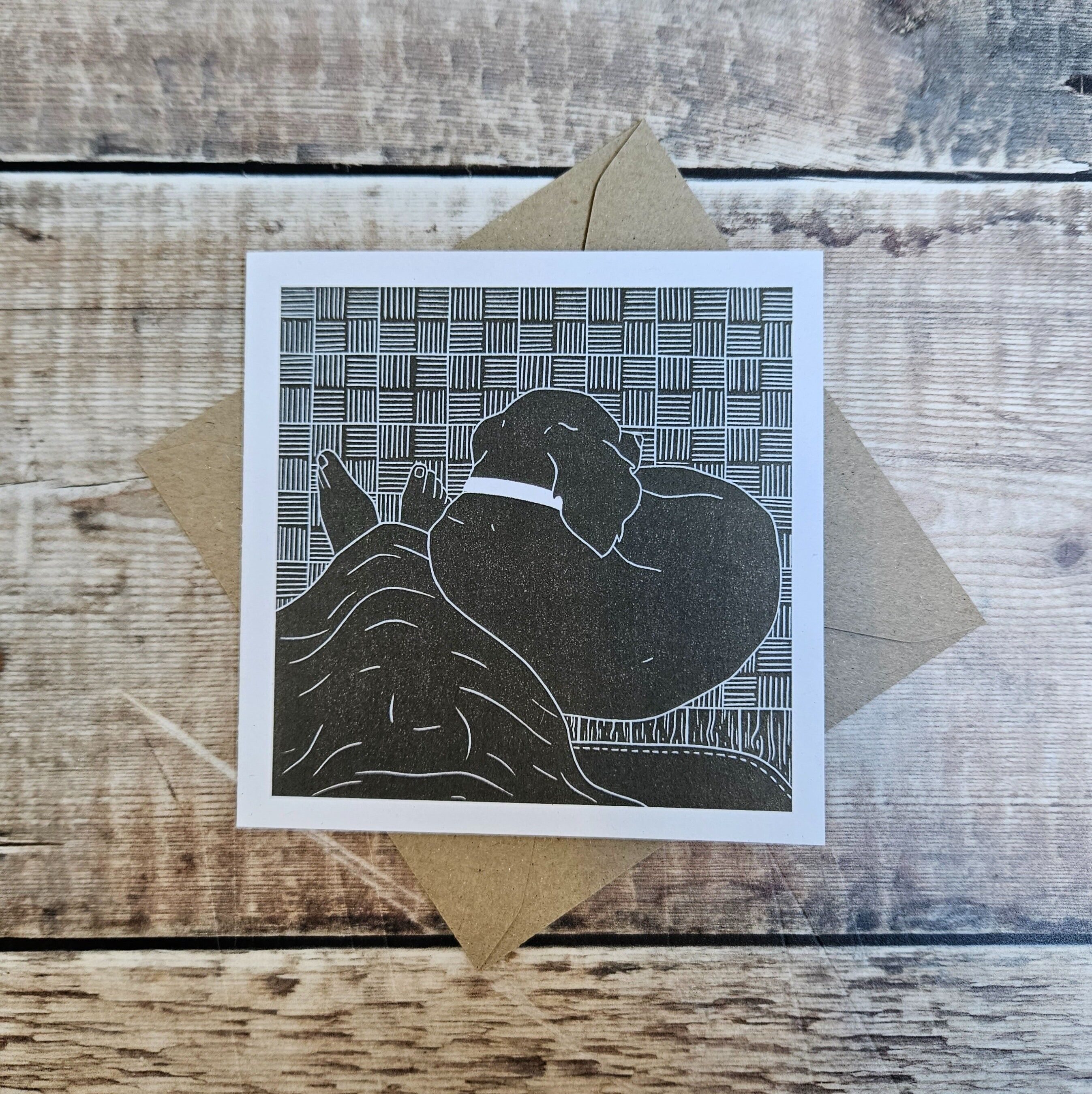 Comfy Cozy - Tarjeta de felicitación en blanco de un perro acurrucado a los pies de los propietarios