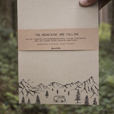 Campistas de bloc de notas de papel de hierba en las montañas