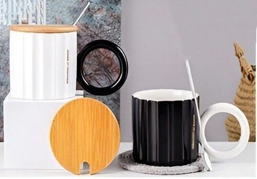 White and black mug with wooden lid and spoon.