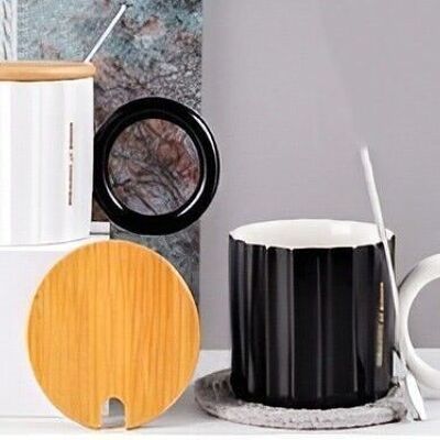 White and black mug with wooden lid and spoon.