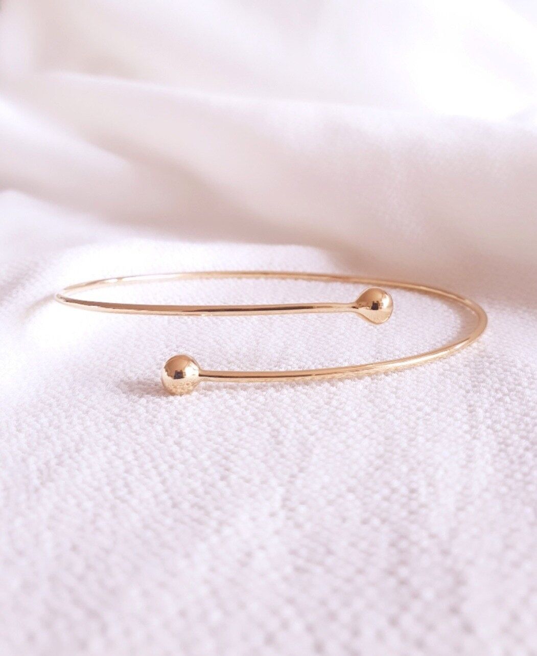 Bangle 1 filo in oro placcato con 1 pallina ad ogni estremità