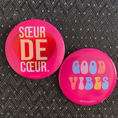 2 grandes chapas con mensaje de 75 mm para alegrar tus cestas y bolsos de playa.