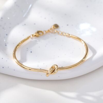 Rigid gold adjustable bangle bracelet with knot