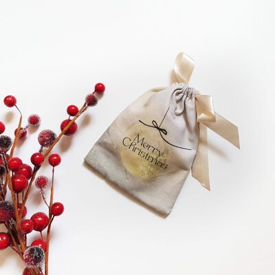 Nachhaltiger Geschenkbeutel mit Goldkugel „Frohe Weihnachten“.