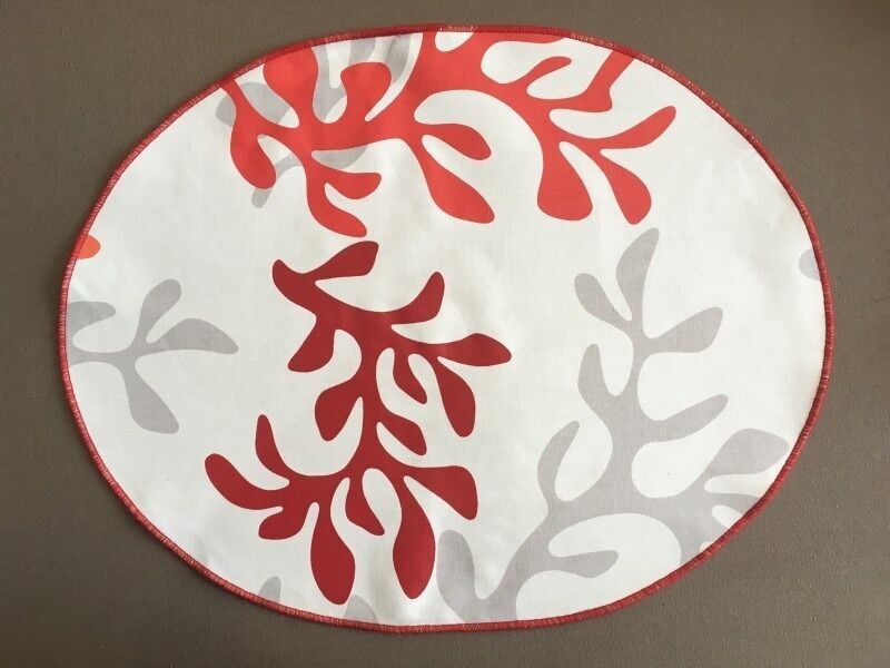 Ovales, beschichtetes Tischset in Korallenrot