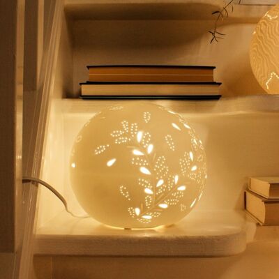 Lámpara de porcelana en forma de esfera con diseño de pétalos dorados.