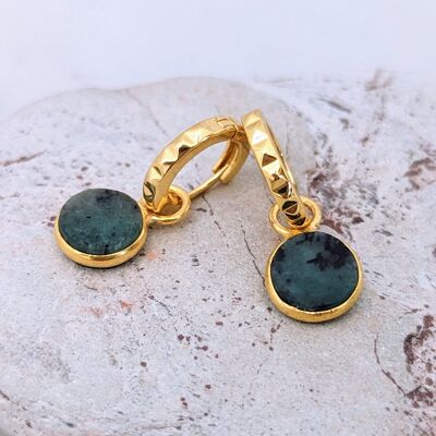 Gli orecchini a cerchio con pietre preziose di smeraldo circolare