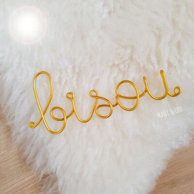 Word "kiss" in gold thread