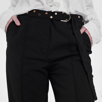 Pantalón negro con pernera ancha y bajo bajo.