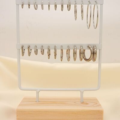 White display with 12 pairs of silver hoop earrings