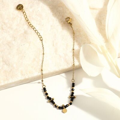 Golden chain bracelet with black pearls and round tassel
