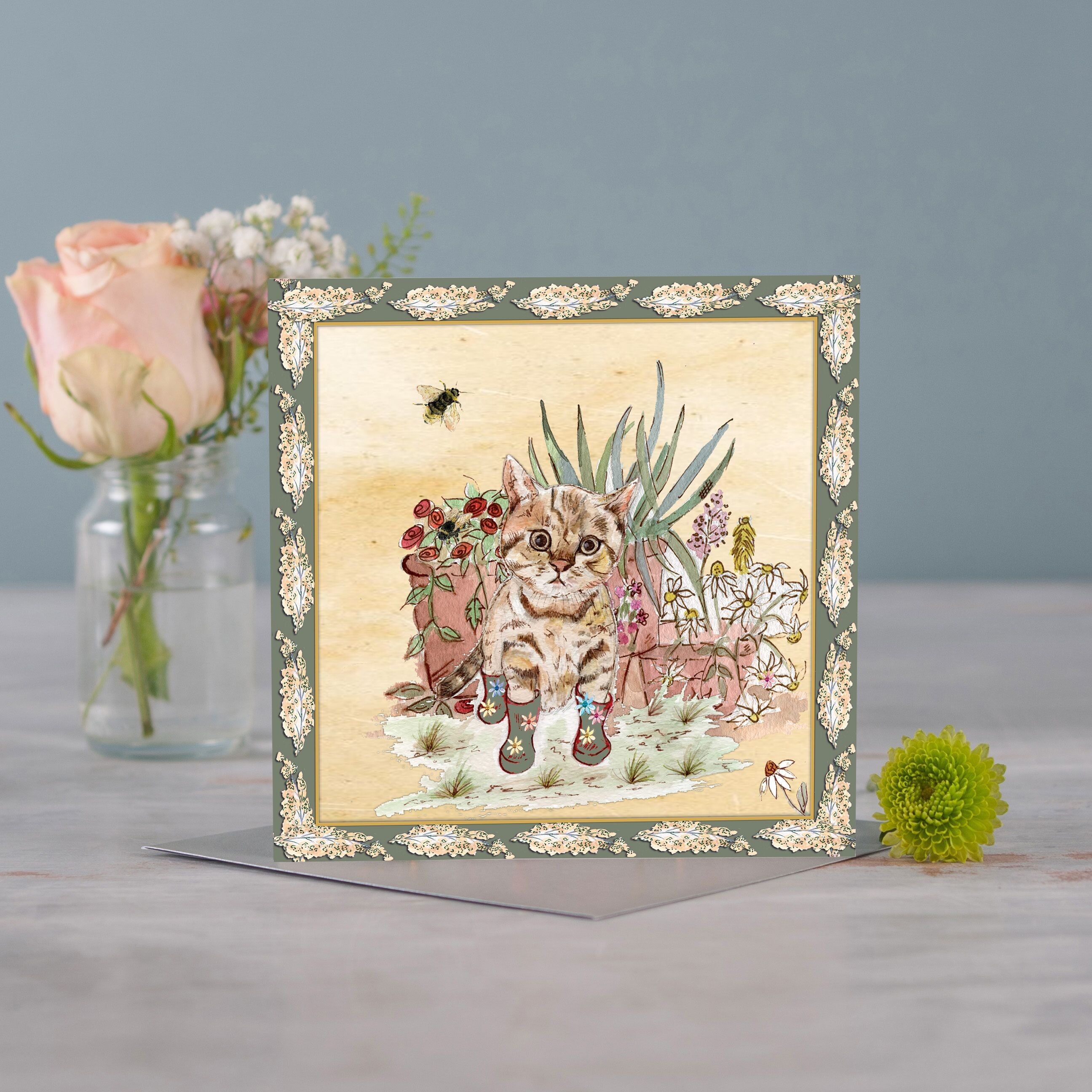 Biglietto d'auguri con bouquet di gattina e stivali