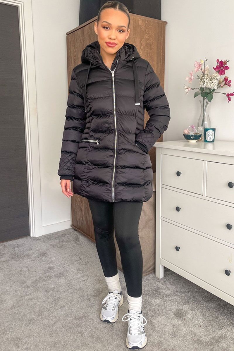 Piumino trapuntato con cappuccio in nero.