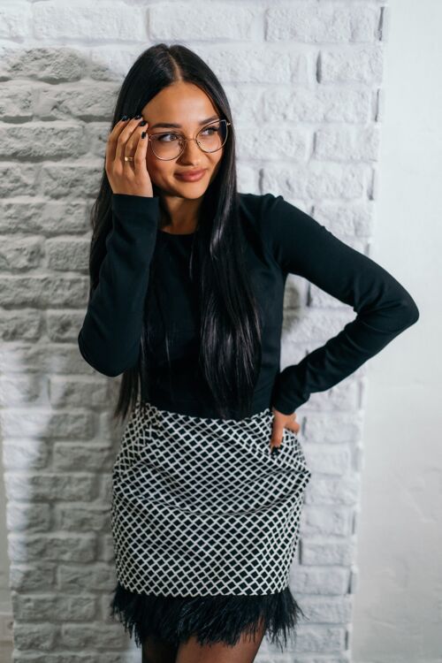 Black and white two-piece dress set of a long-sleeved top and feather skirt with pockets