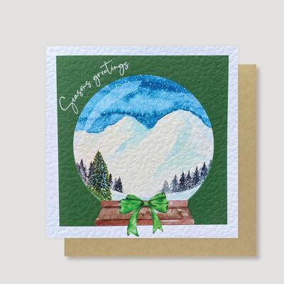 Cartolina di Natale con globo di neve in montagna