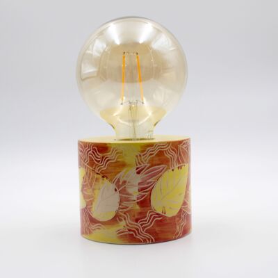 Moderna lámpara de mesa tallada y pintada a mano en rojo y amarillo con una bombilla de globo gigante