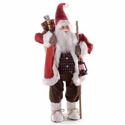 Shop window Santa Claus in a red suit with faux eco-fur details, gifts and lantern