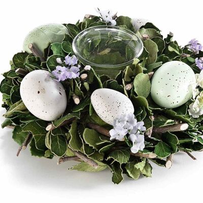 Table centerpiece of Easter eggs and flowers with glass candle jar