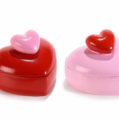 Heart-shaped containers in pink and red colored resin with lids with an embossed heart