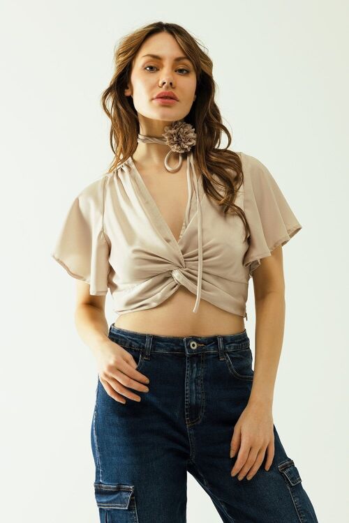 Crop top beige con escote en pico, manga corta y detalle de flores en el cuello