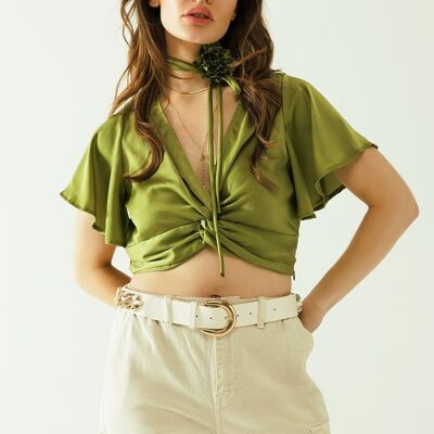 Crop top verde con escote en pico, manga corta y detalle de flores en el cuello