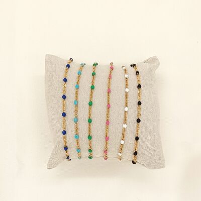 Conjunto de 6 pulseras de cadena de oro de colores sobre cojín.