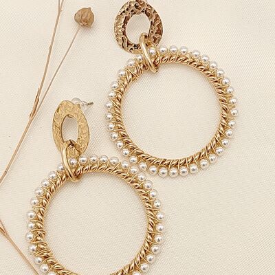 Pendientes de oro con círculo grande rodeados de perlas.