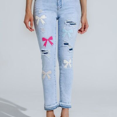 Jeans super skinny azzurri con papillon e fori strappati