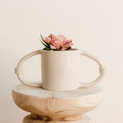 Jardinera de cerámica beige con diseño minimalista circular.