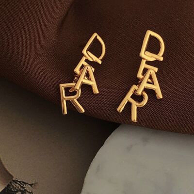 Ineinander verschlungene DEAR-Buchstaben: Romantische Ohrringe mit verspielter minimalistischer Essenz