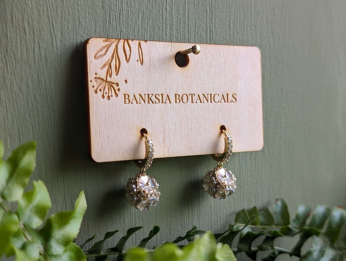 Orecchini Huggie floreali in oro con zirconi cubici