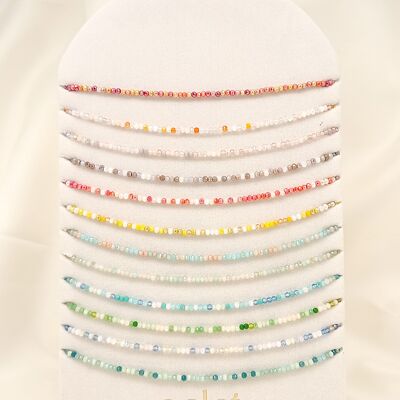 Conjunto de 12 collares coloridos con cristales de vidrio en exhibición.