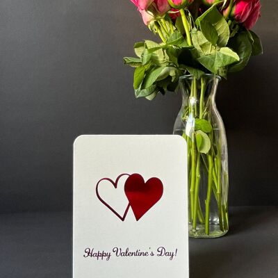 Tarjeta del día de San Valentín: corazones con texto en lámina roja