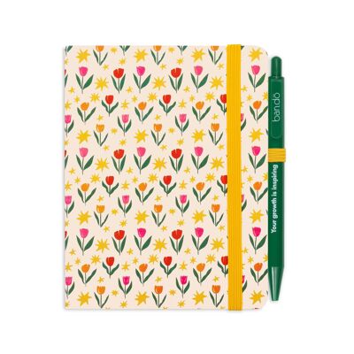 Mini cuaderno con bolígrafo, tulipanes sobre crema