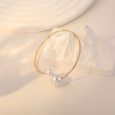 Fine golden bangle bracelet with two pearl clasps