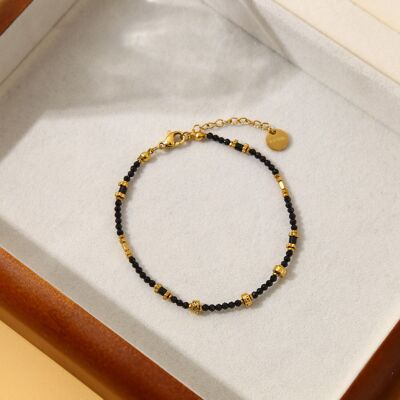 Golden bracelet with black and gold stones