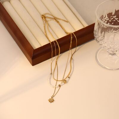 Triple chain necklace with pearls and dangling sun