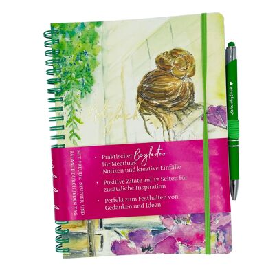 Cuaderno con bolígrafo, práctico compañero con citas positivas.