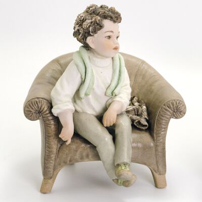 Figura de porcelana Giulio en un sillón.