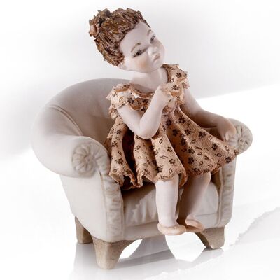 Figura de porcelana Pauline en un sillón.