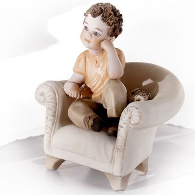 Figura de porcelana Renato en un sillón.
