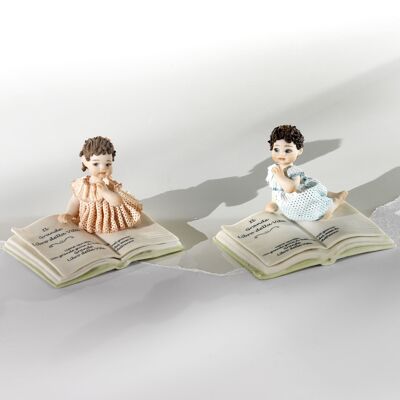 Figuras de porcelana de recién nacidos acostados sobre el Libro de la Vida.
