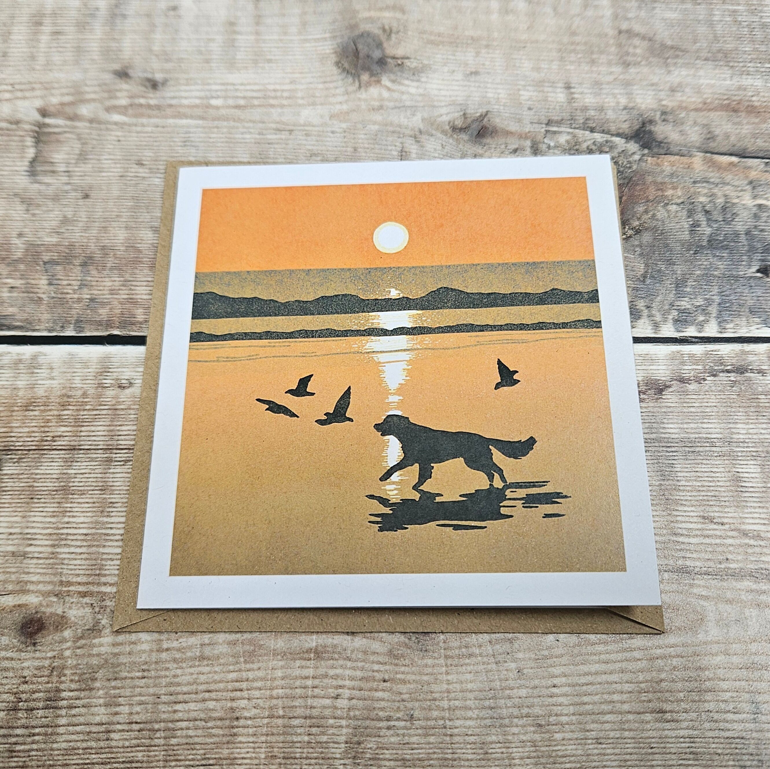 Giving Chase- Tarjeta de felicitación en blanco con un perro persiguiendo pájaros en la playa