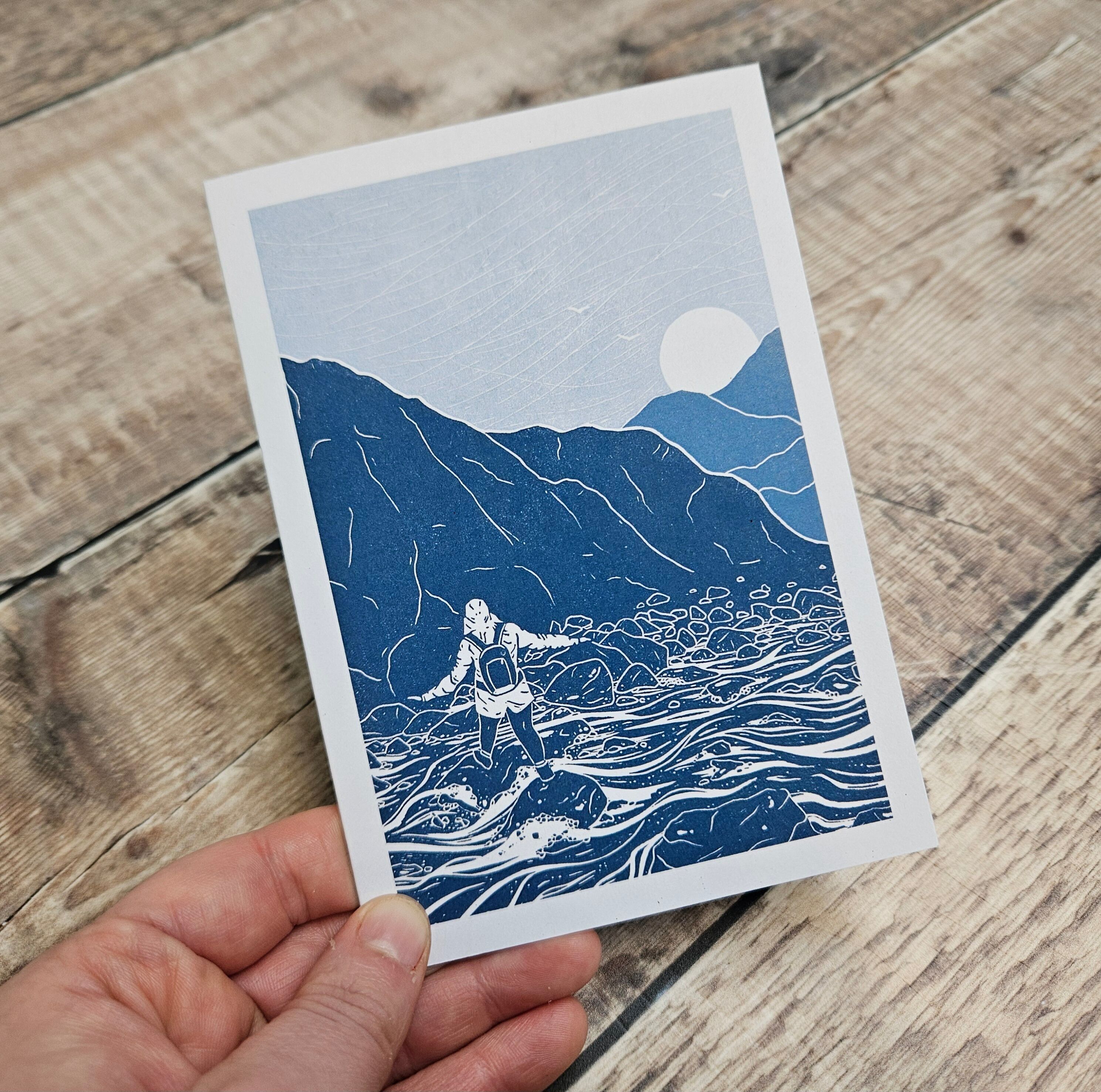 Stepping Stones - Blank greetings card featuring a person crossing a waterfall in the mountains