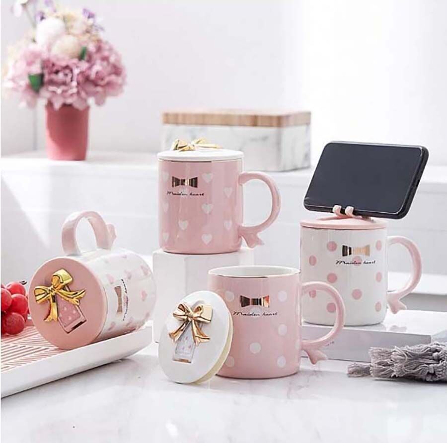 "BOW" ceramic mug with a lid that becomes a stand for a mobile phone in 4 designs with polka dots. Dimension: 8.5x9.5cm Capacity: 380ml LM-621