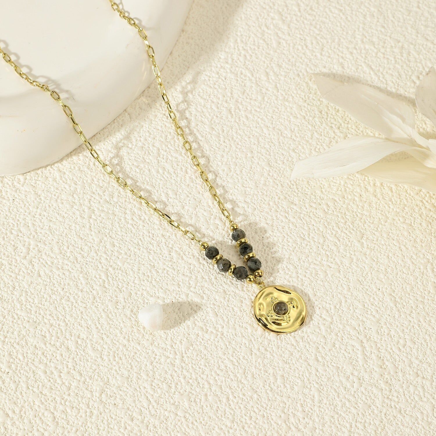 Collana a catena dorata con nappa martellata in pietra grigia