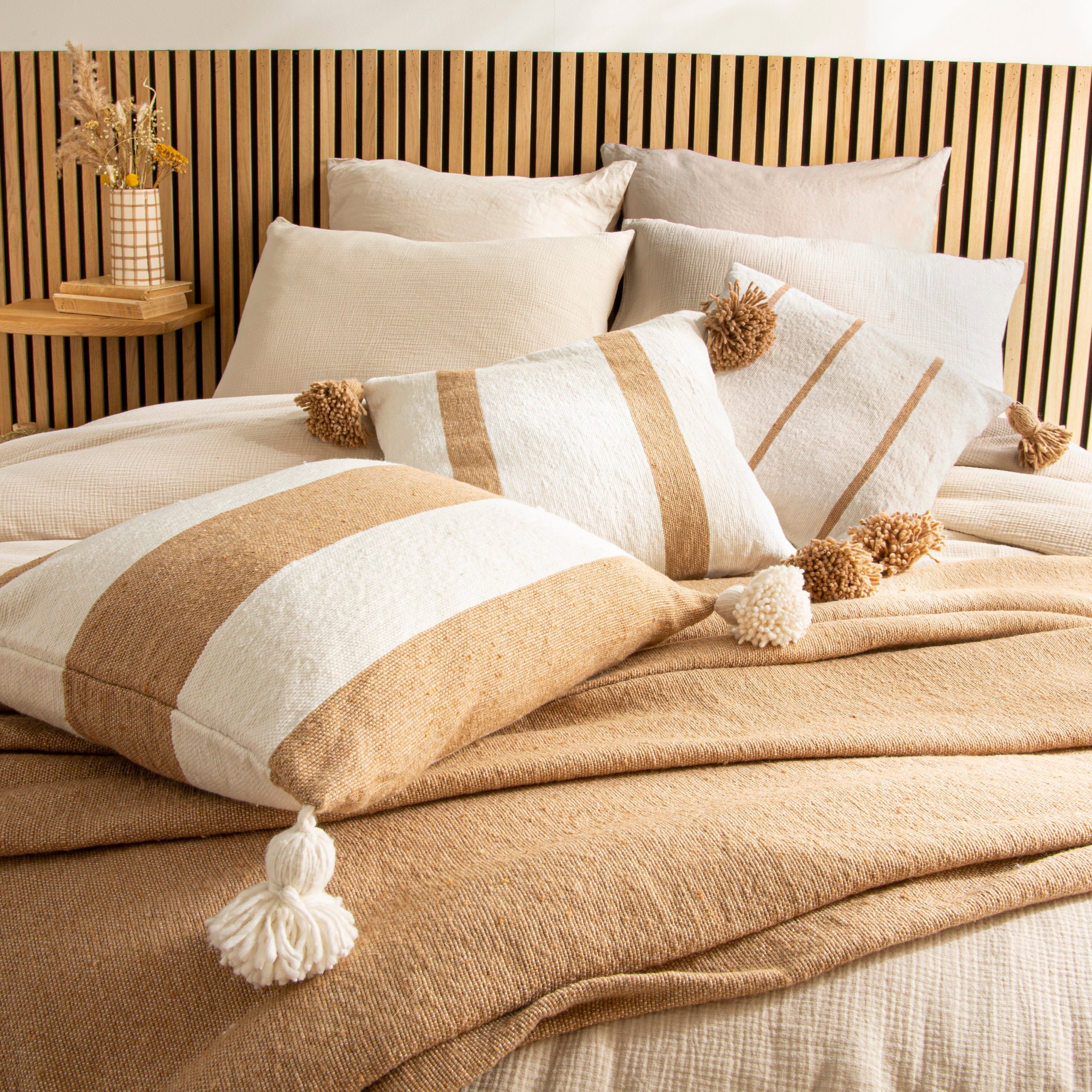 Cuscino con pompon ecrù a righe larghe cammello